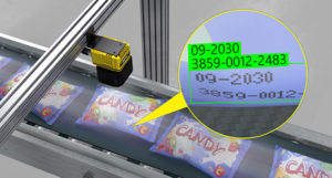 sensor o cámara de visión amarillo y negro leyendo y detectando caracteres en paquetes de golosinas